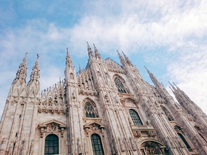 Low angle view of duomo di milano against cloudy sky