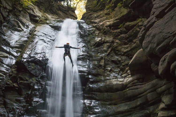 No hands while rappelling in the middle of a waterfall.