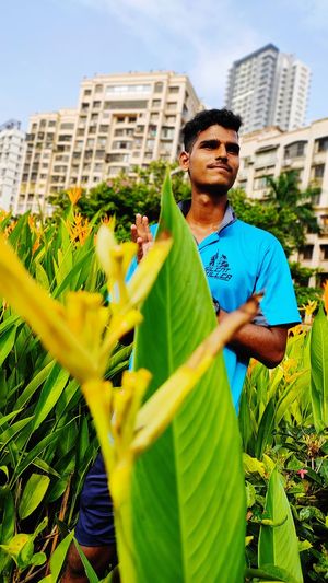 Full length of young man holding flower in city