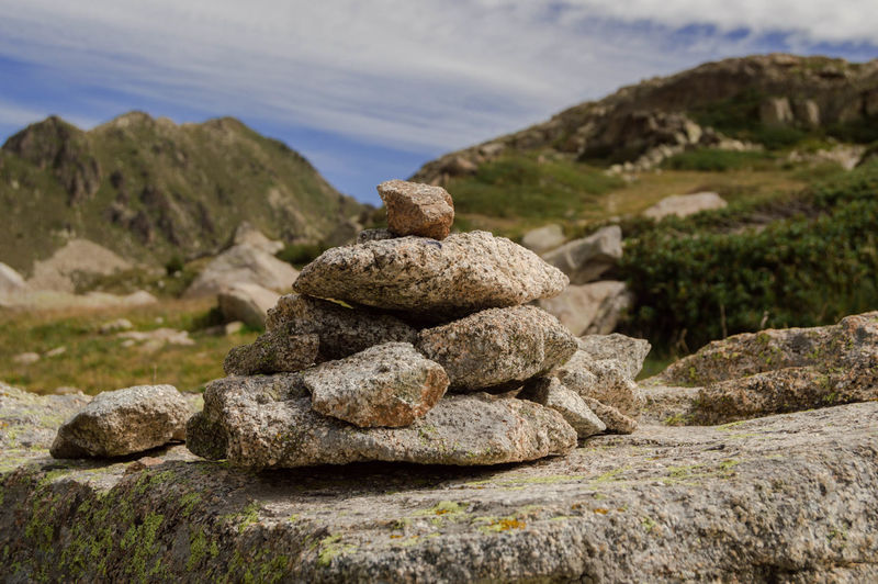Stack of stones on rock against sky