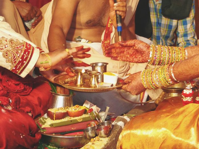 Cropped image of bride and groom performing rituals during wedding