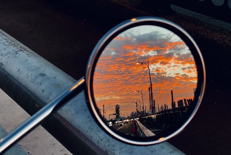 Reflection of cityscape on side-view mirror