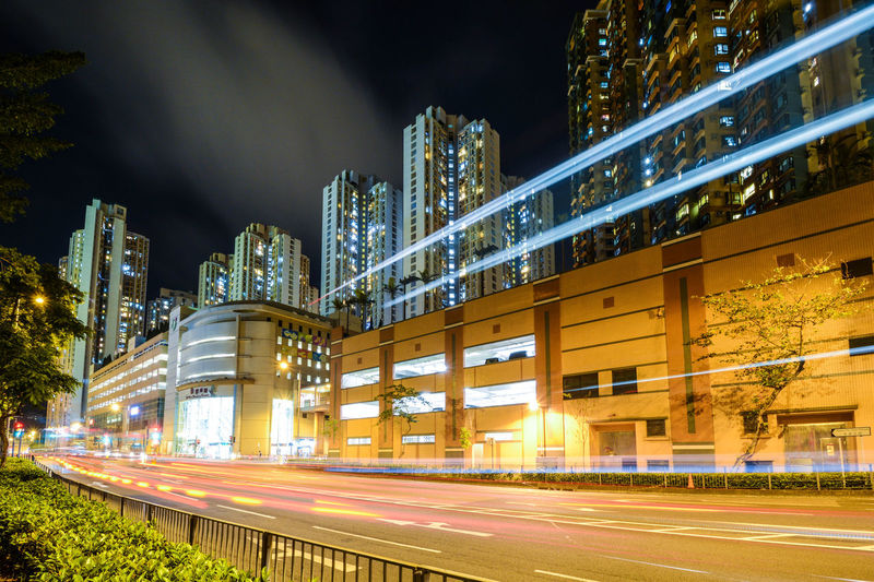 Light trails on road by buildings in city at night in hong kong 