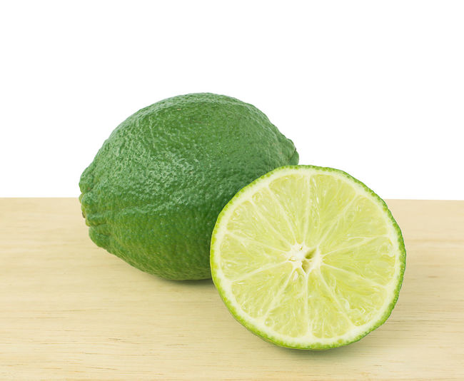 Close-up of lemon slice on table against white background
