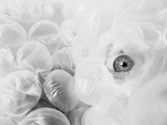 Close-up of human eye amidst plastic bags