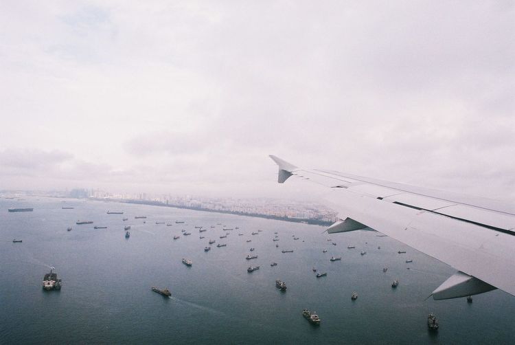 Airplane flying over sea against sky
