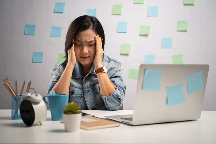 Thoughful woman with eyes closed by objects on table