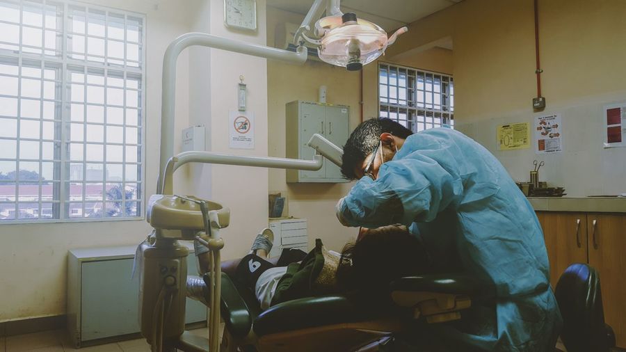 Dentist examining patient at clinic