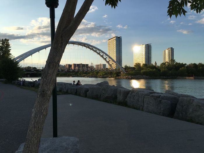 Bridge over river against cloudy sky
