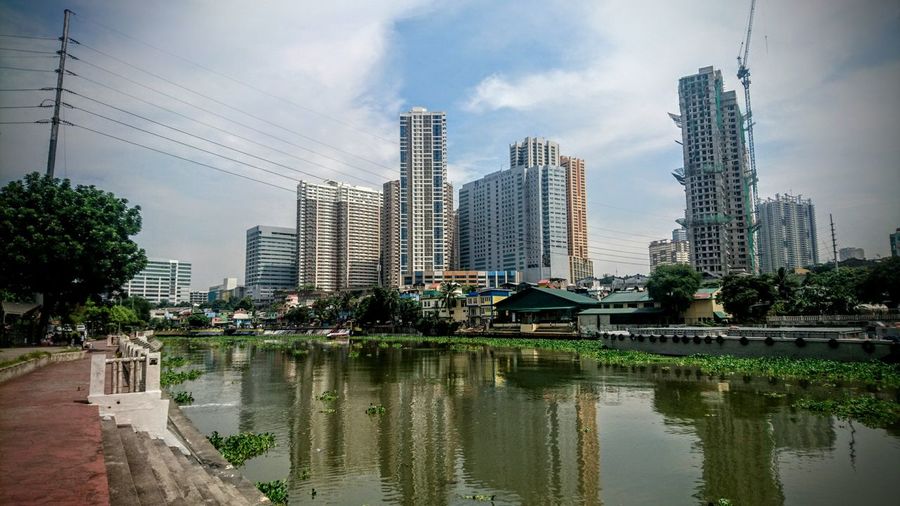 Cityscape by pasig river against sky