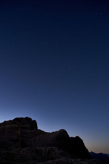 Low angle view of rock formation against clear blue sky