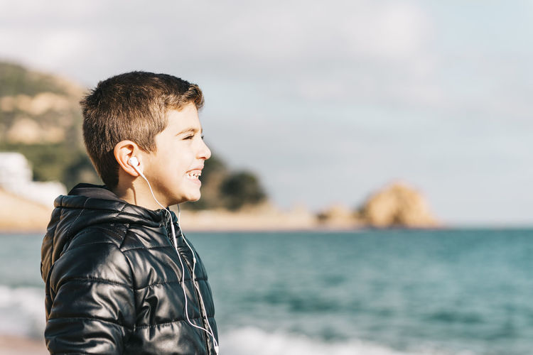 Side view of young man looking at sea