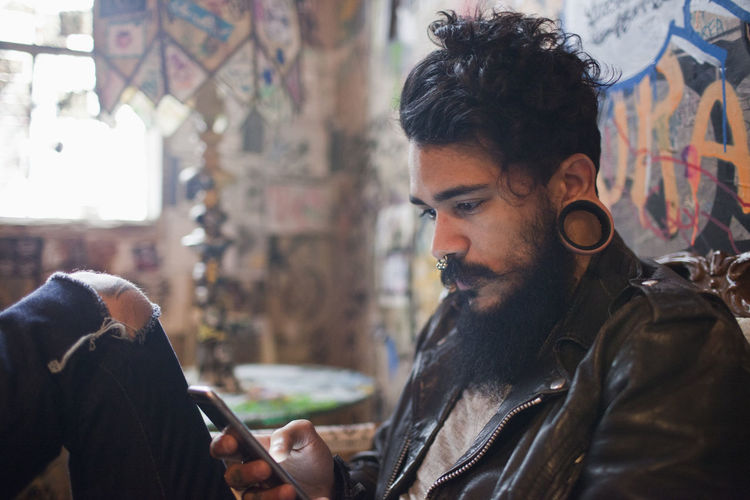 Hip man using a cell phone in bar