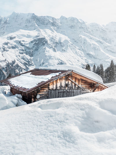 Houses on snowcapped mountain against sky