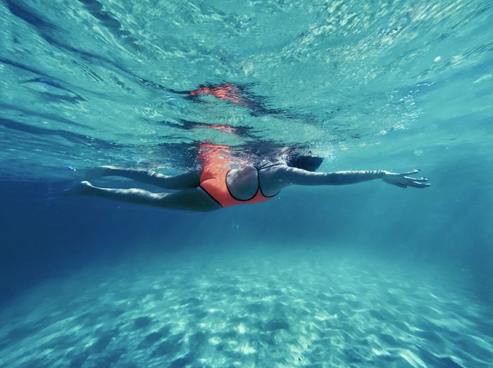 Underwater view of woman swimming in sea
