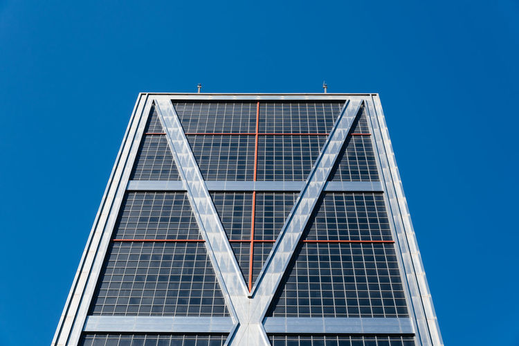 Low angle view of office building against clear blue sky