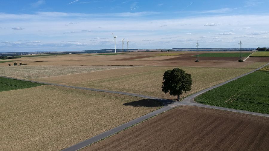 Scenic aerial view of agricultural field against sky
