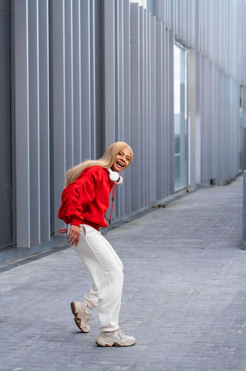Cheerful african american woman with long blonde hair wearing sportswear and wearing headphones