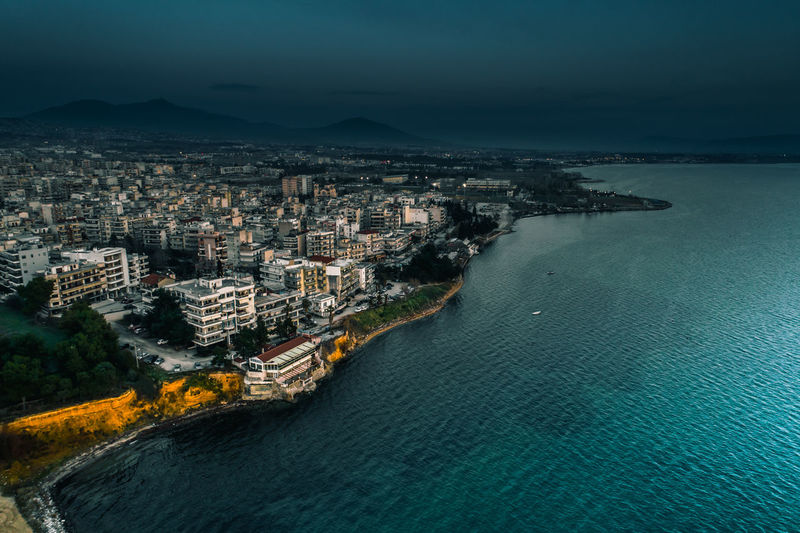 High angle view of cityscape by sea against sky