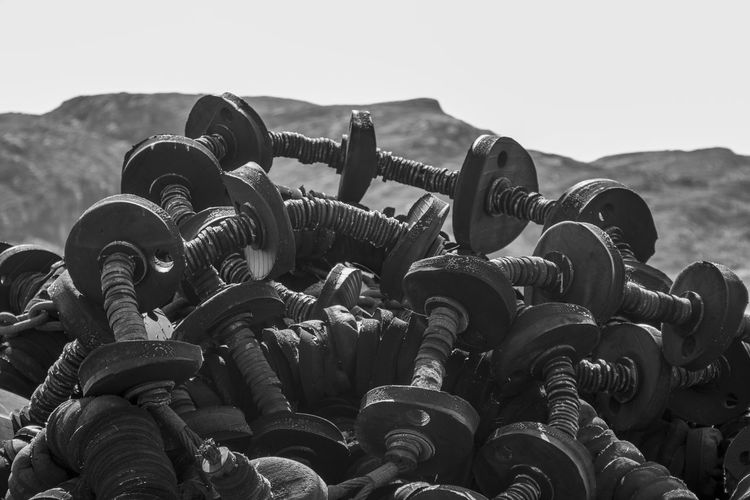 Black and white photo of fishing gear piled up next to mountain