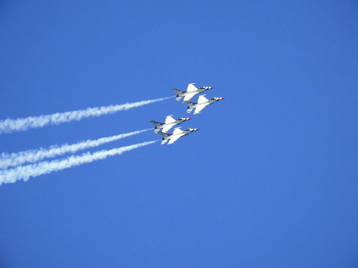 Low angle view of airshow against clear blue sky
