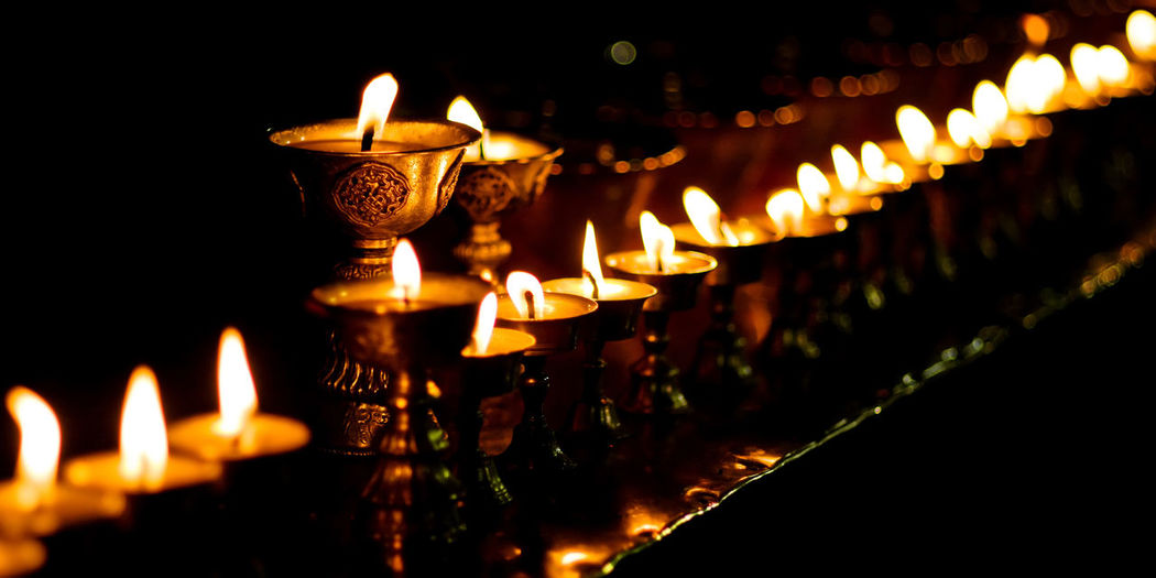 Close-up of lit candles in temple