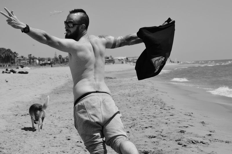 Full length of shirtless man on beach