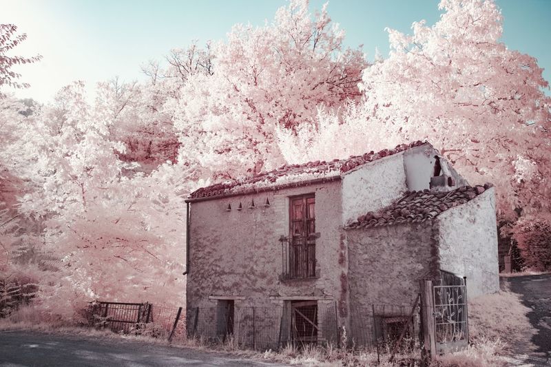 Infrared photograph of abandoned building against sky