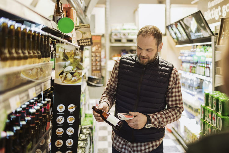 Man scanning beer bottle at grocery store