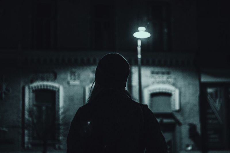 Rear view of a man standing at night