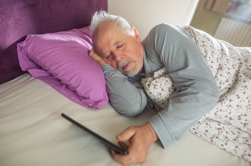 Midsection of man lying on bed at home