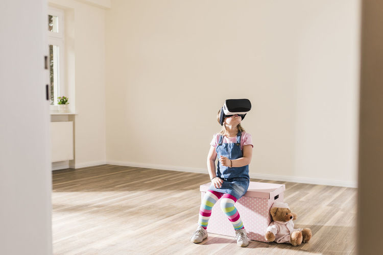 Girl in empty apartment wearing vr glasses