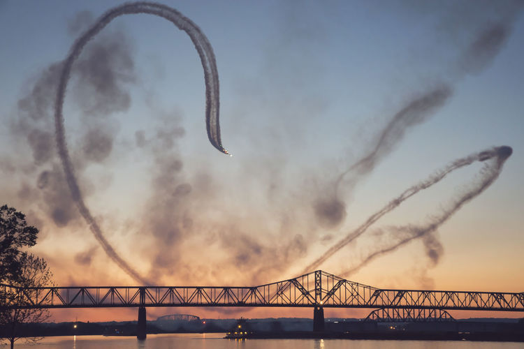 George rogers clark memorial bridge over ohio river against sky during sunset