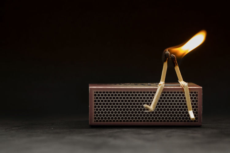 Close-up of burning candles on wood