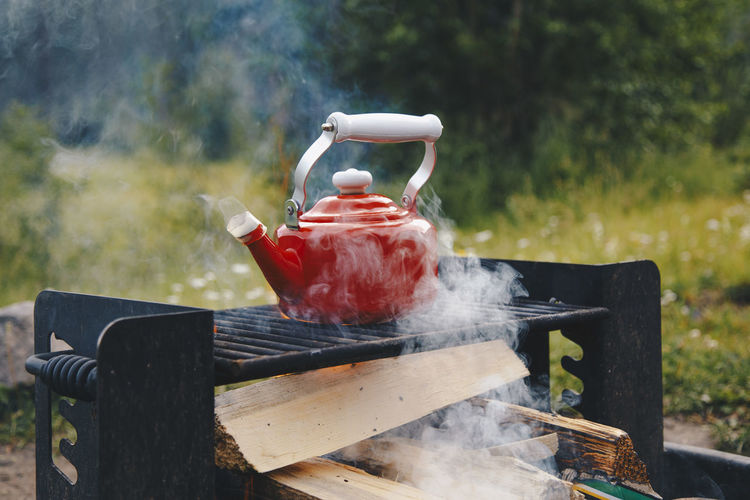 Heating up water in a red kettle while camping