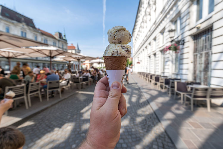 Cropped hand of man holding ice cream outdoors