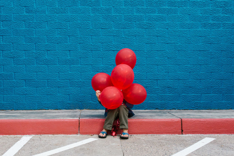 Low section of woman with red balloons
