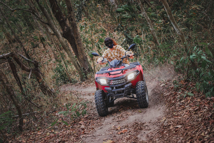 Woman riding atv in forest