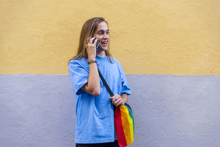 Young woman standing against wall