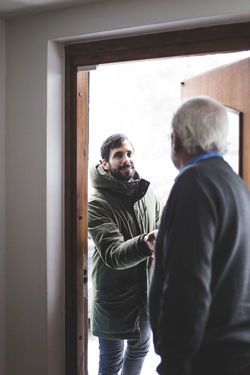 Therapist greeting patient at doorway in home office