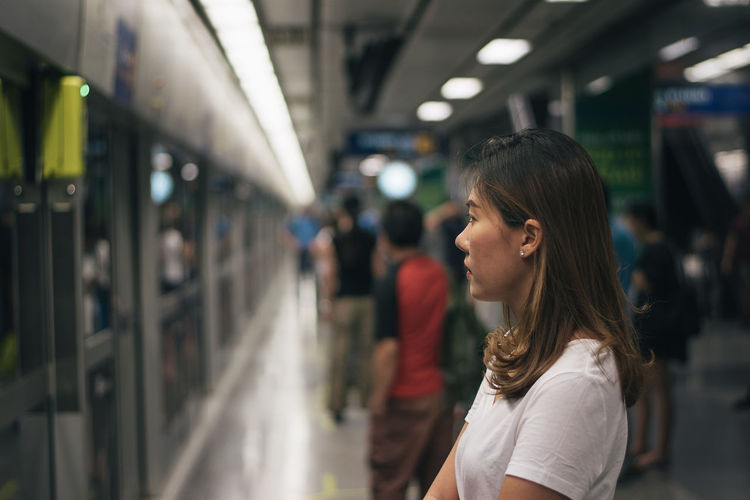 Midsection of woman standing on train at railroad station