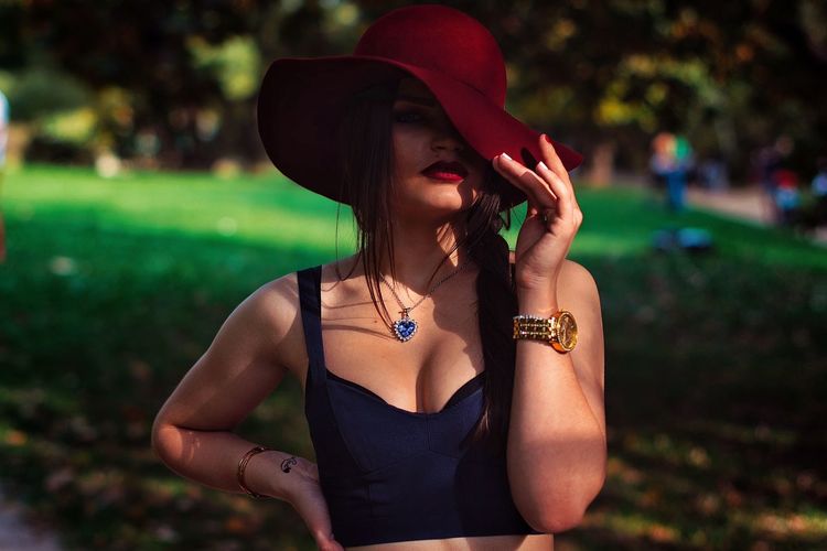 Portrait of sensuous woman wearing red hat in park