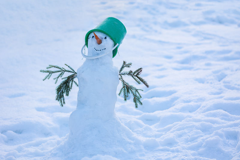 Happy snowman on snow in winter new year landscape. beautiful christmas snowy 