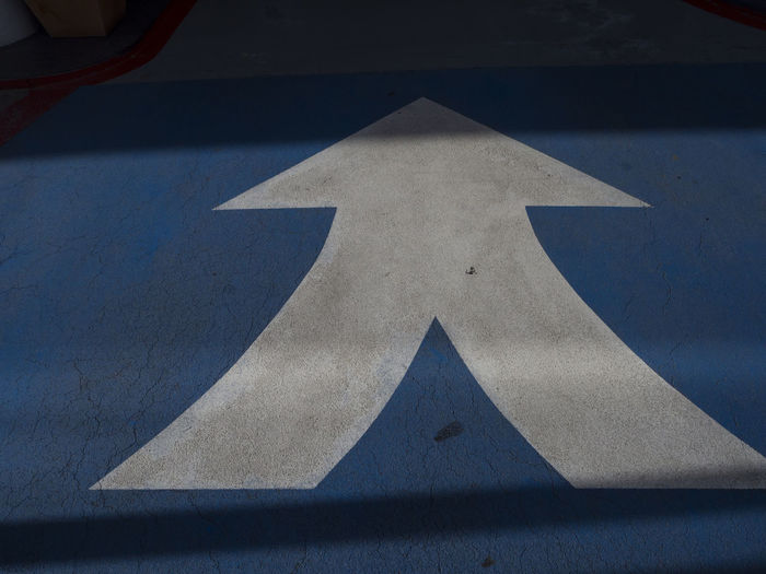 High angle view of arrow sign on paper