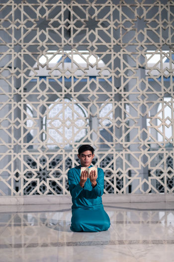 Young man reading quran in mosque