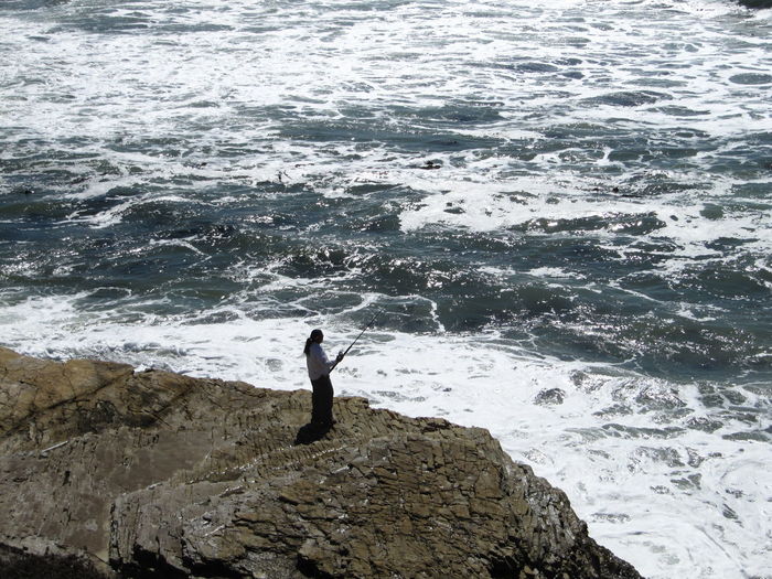 Woman standing on rocks at sea shore