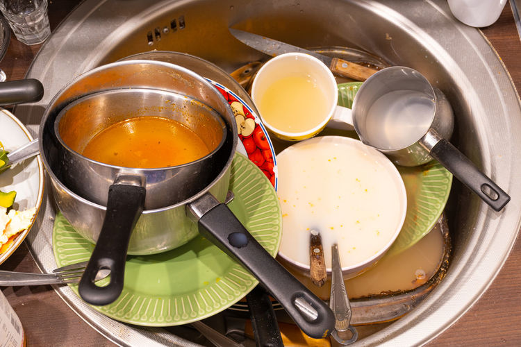 Dirty cutlery, dishes, plates and pans in a sink during quarantine or lockdown, need to wash