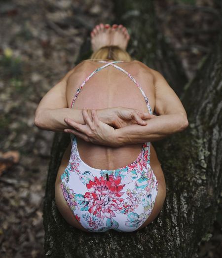 Rear view of woman standing against tree