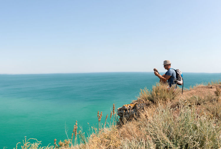 View over turquoise sea in bulgaria with adult man photographing