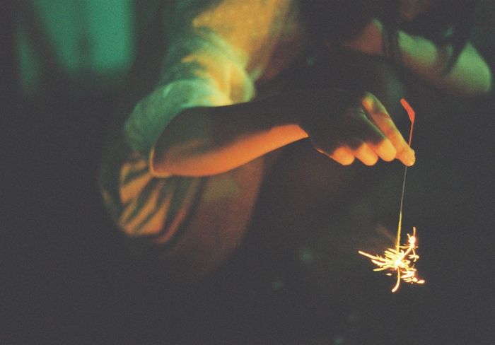 Low section of woman holding sparkler